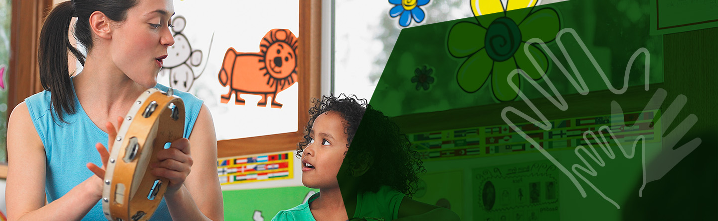 Sozialpädagogik Header: Eine Erzieherin spielt in einem Kindergarten neben einem Kind Tamburin.